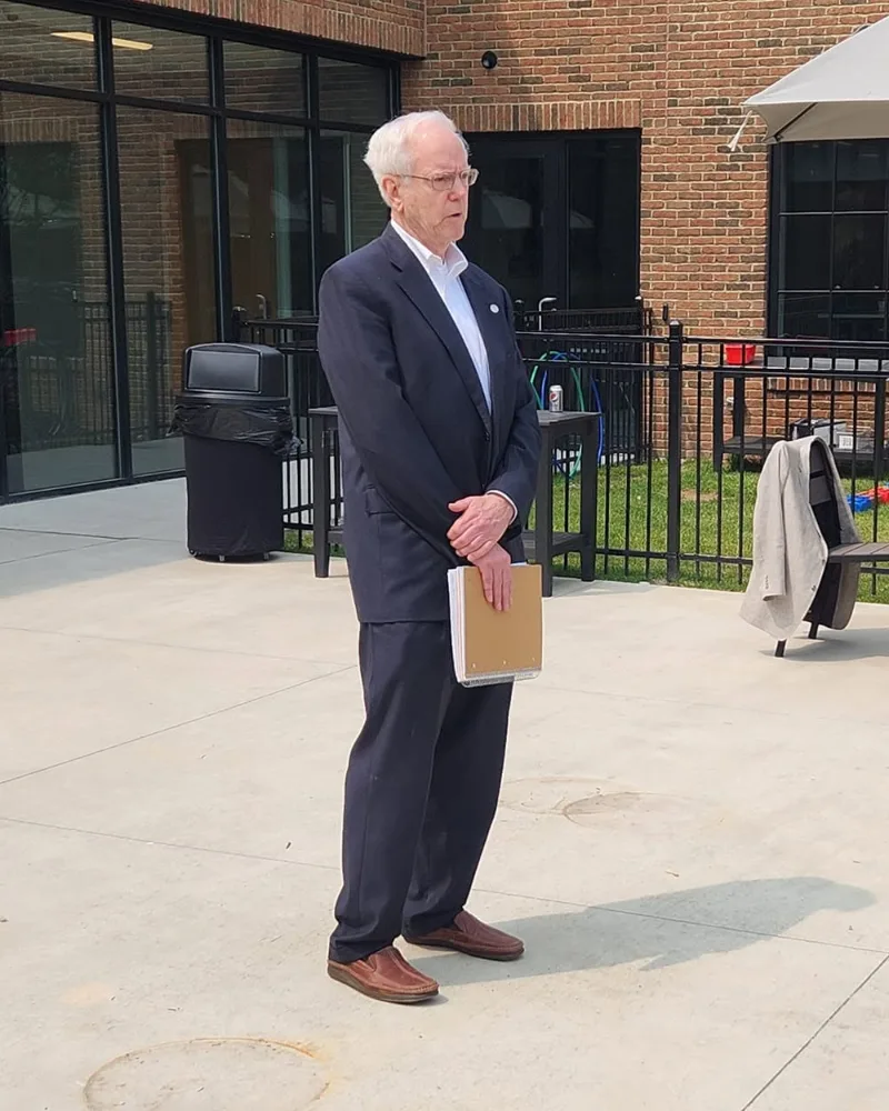 Tom Kuhn standing alone on an empty patio
